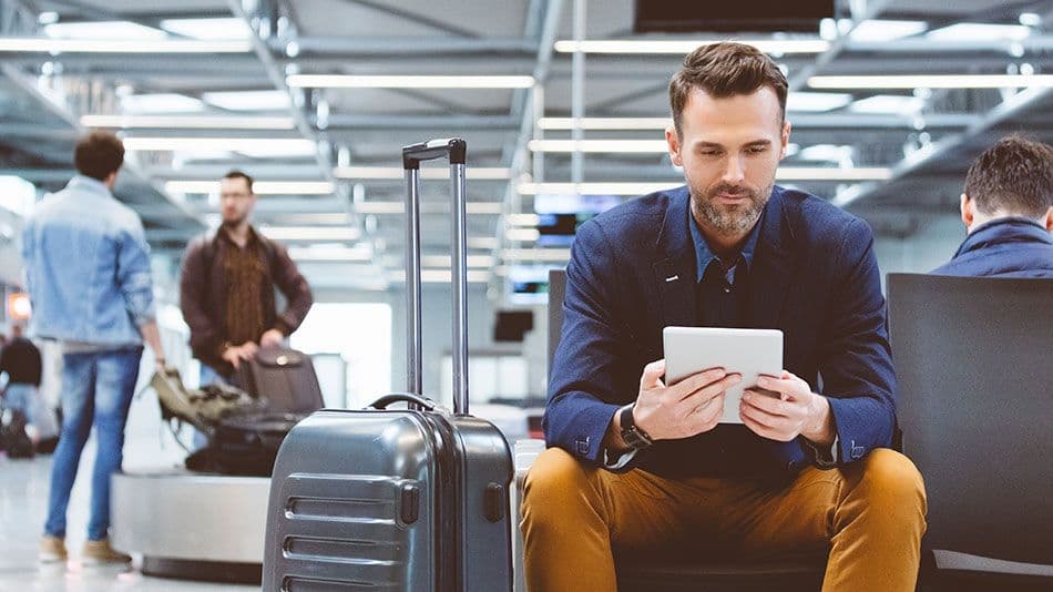 guy sitting in aiport on ipad