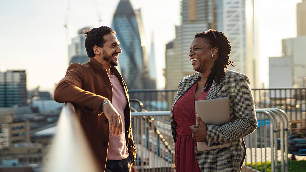 Homme et femme souriant sur le pont avec la ville en arrière-plan